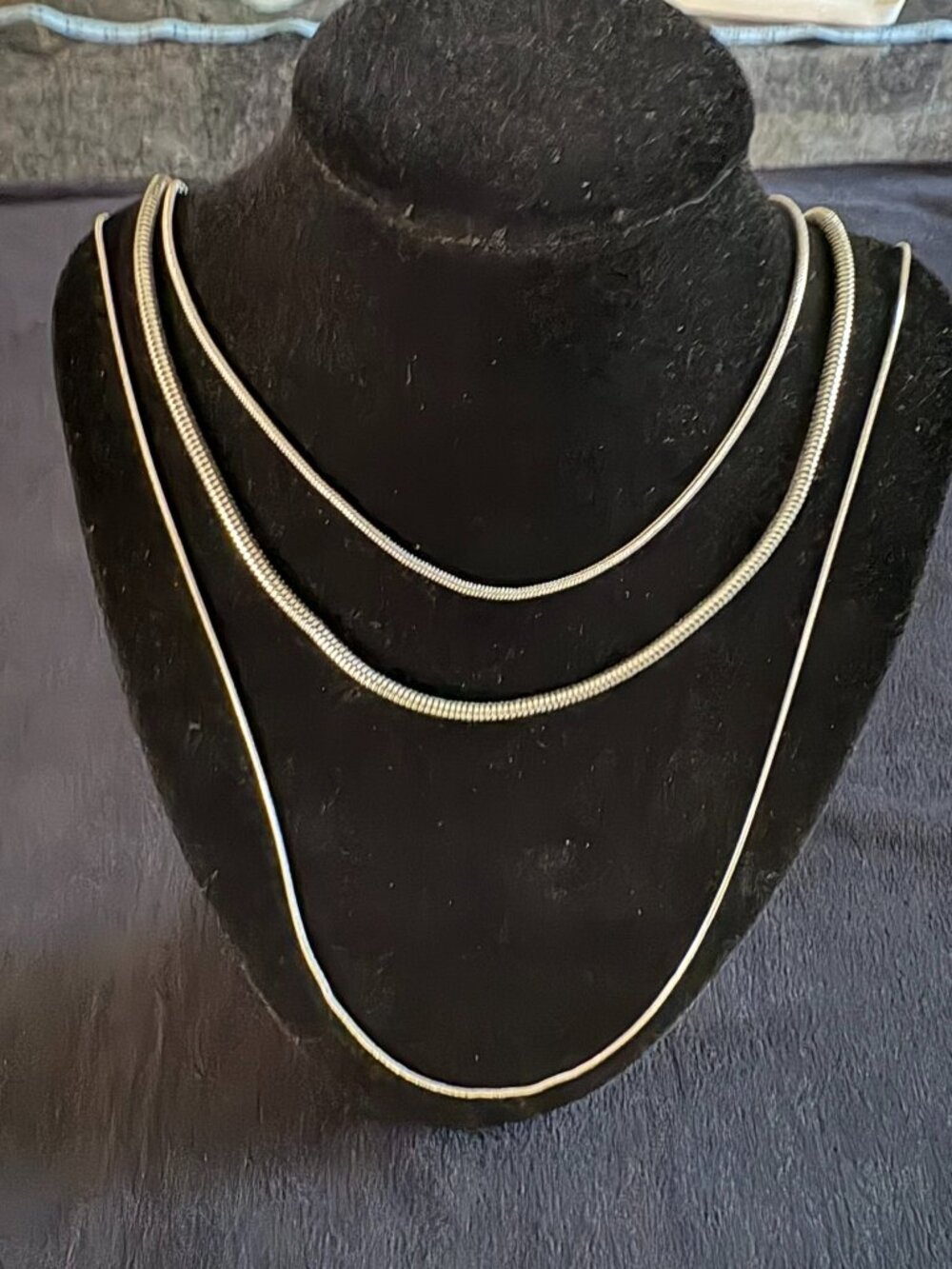 Silver colored three strand necklace of varying thicknesses